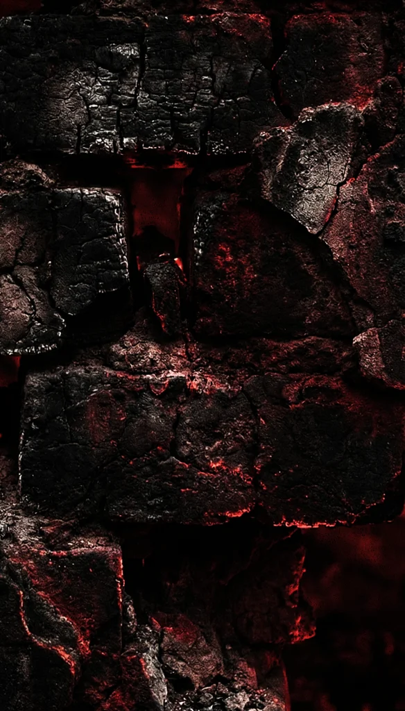 תקריב של סלעים כהים ומחוספסים עם אור אדום עז הבוקע מבין הסדקים, במראה המזכיר לבה רותחת או גחלים.